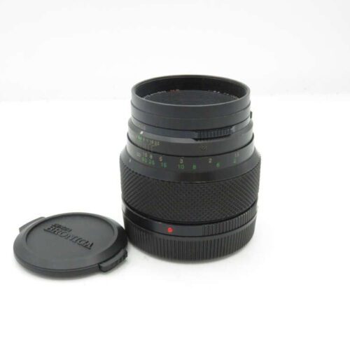 Black camera lens with cap beside it on a white background.