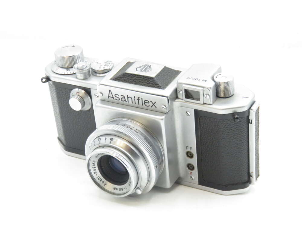 IMG_0703 Vintage Asahiflex camera with a silver body and black leatherette accents, featuring a prominent lens and multiple dials on the top.