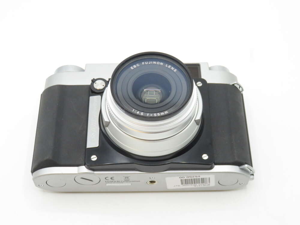 A vintage-style camera with a black grip and a silver body, featuring an EBC Fujinon lens with a focal length of 55mm.