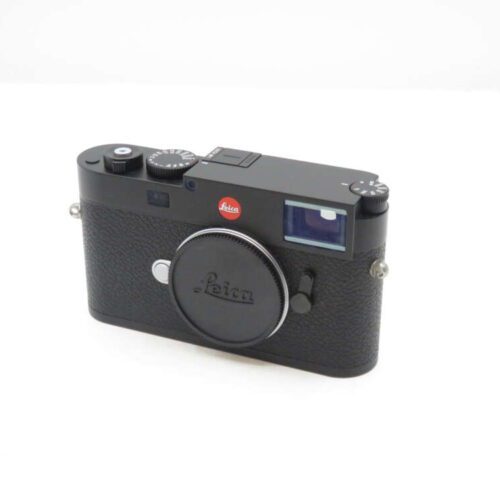 A black Leica camera with a body cap, featuring the red Leica logo on the front.