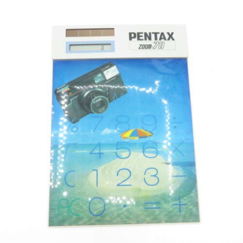 Pentax Zoom 70 calculator featuring a beach-themed design with a camera and an umbrella graphic.