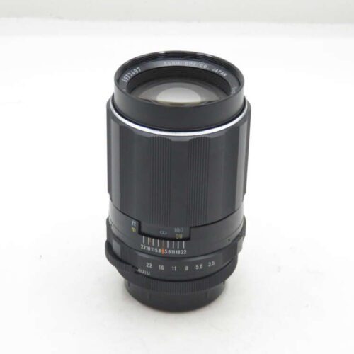 A black Asahi camera lens with focus and aperture rings, featuring distance markings in feet and meters.