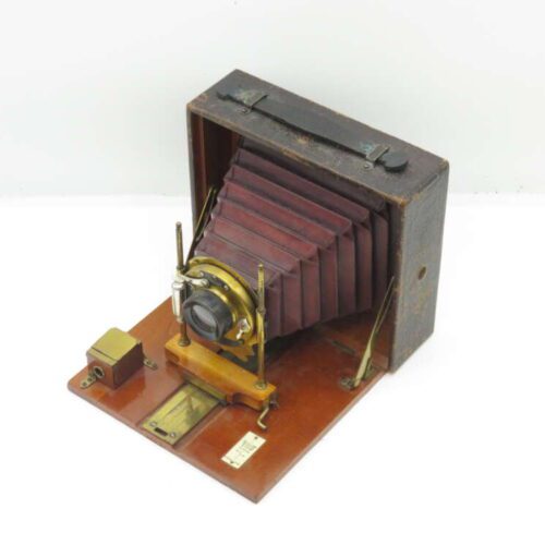 Vintage bellows camera with wooden base and brass fixtures.