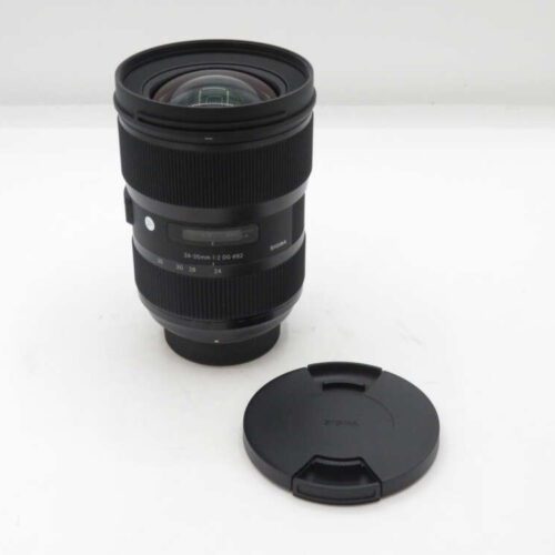 Black camera lens with a detachable lens cap on a white background.