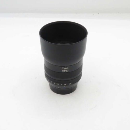 Zeiss Touit 1.8/32 camera lens on a white background.