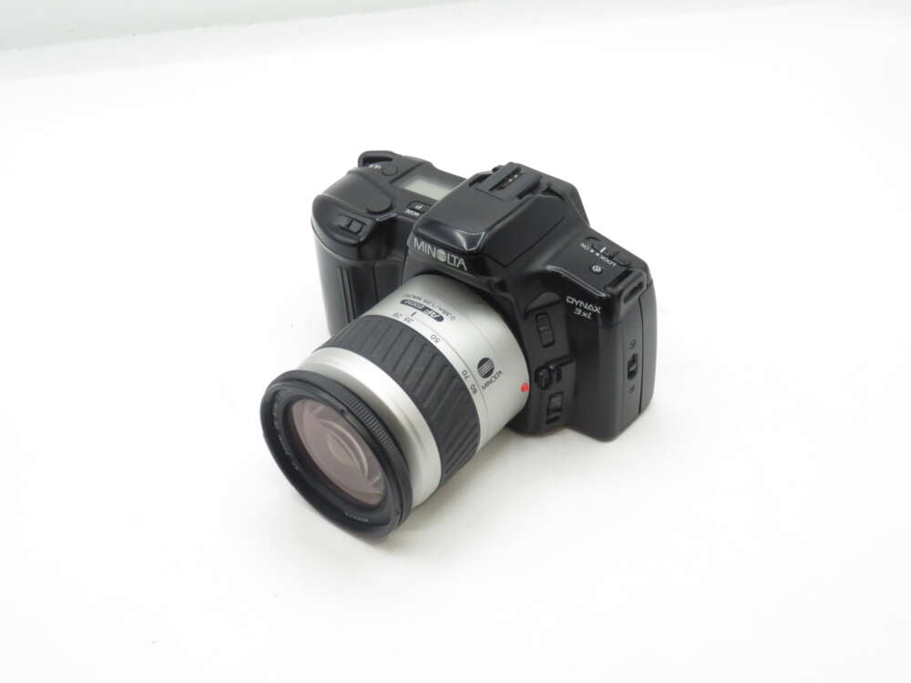 IMG_1955 Minolta Dynax 3L film camera with a silver lens on a white background.