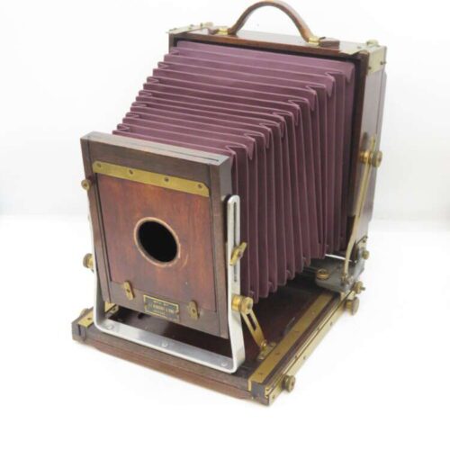 Vintage large format camera with bellows and wooden frame.