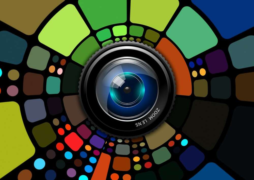 A camera lens surrounded by a mosaic of colourful geometric shapes.