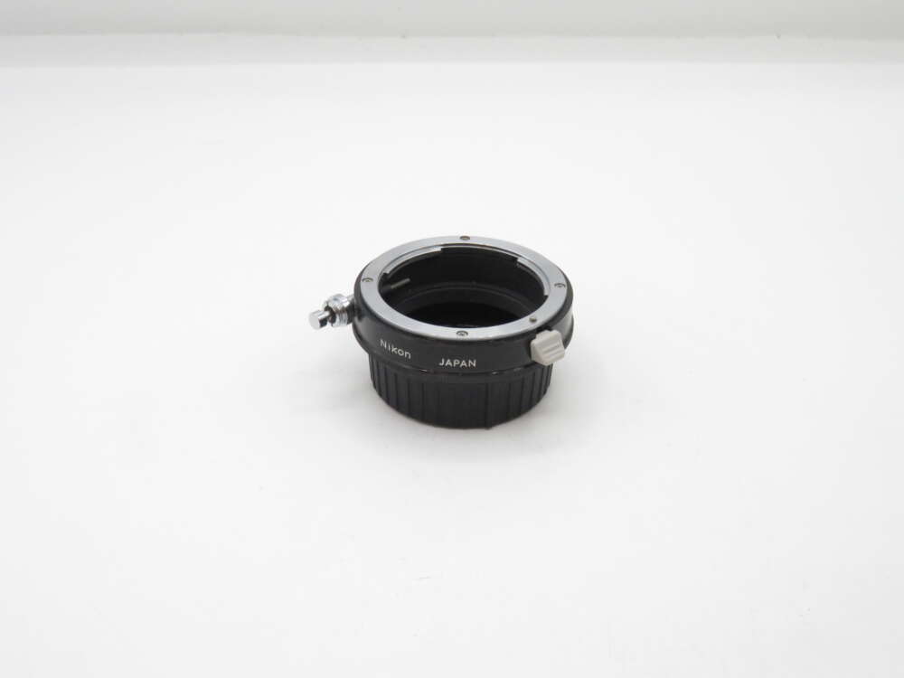 IMG_2941 Nikon camera lens adapter on a white background.