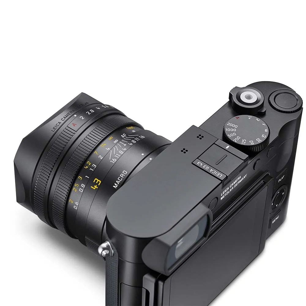 A black Leica camera with a lens displaying focal length markings and a macro setting.