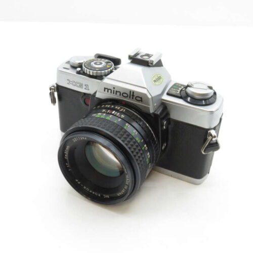 A vintage Minolta XG1 film camera with a lens attached.