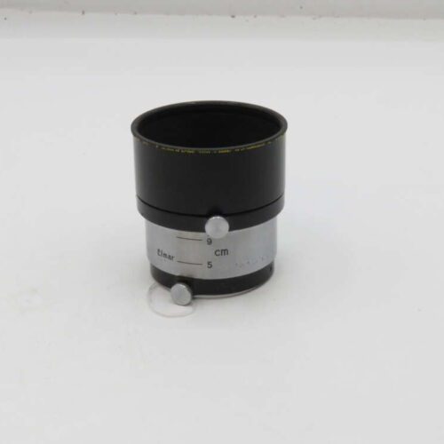 A black and silver vintage camera lens marked "Elmar" with a distance scale in centimetres.