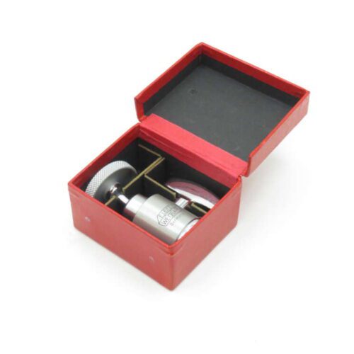 Open red box containing a small metal cylinder and additional components.