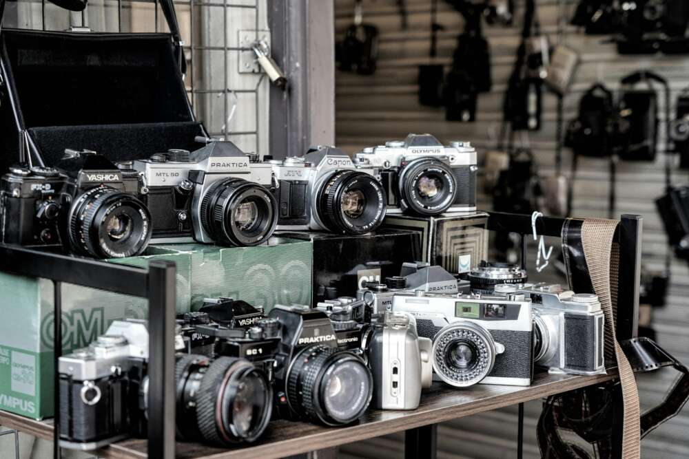 A collection of vintage cameras displayed on shelves.