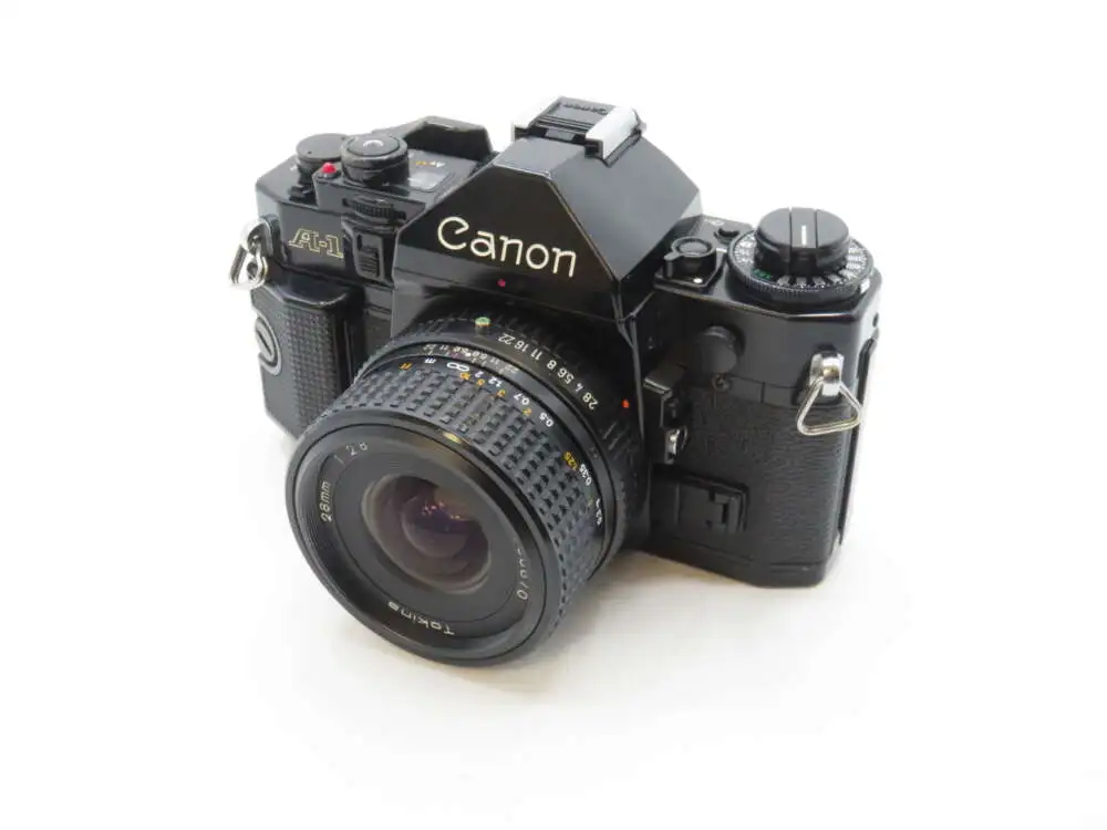 A Canon A-1 film camera with a Tokina 28mm lens attached.