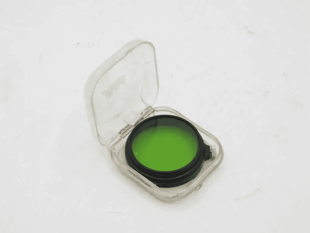 A green camera filter in a transparent plastic case.