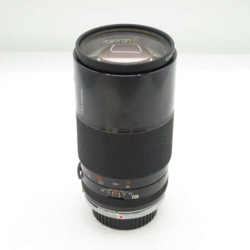 Tamron camera lens with focus and aperture dials on a white background.