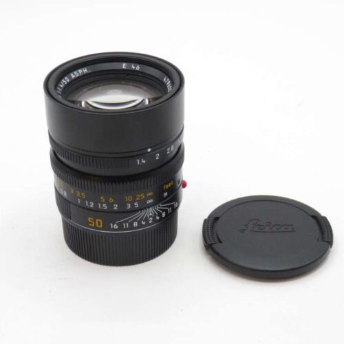 Leica camera lens with cap on a white background.