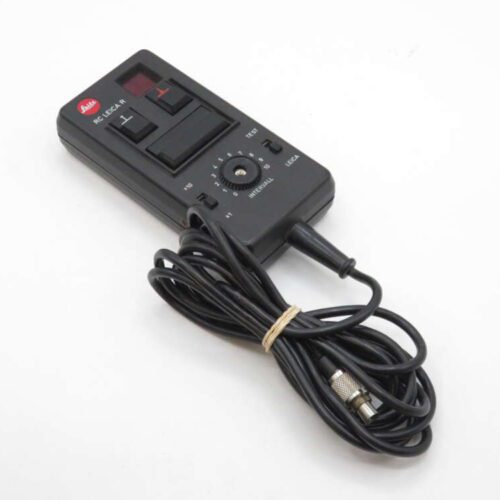 A Leica RC LEICA-R remote control device with a coiled black cable and a connector, featuring several buttons and a dial for settings.