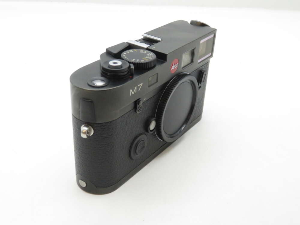 Alt text: Black Leica M7 film camera with a textured grip and a lens cap attached.