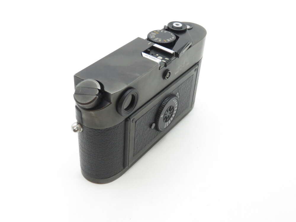 A vintage black camera body with textured grip and silver details, viewed from the back and slightly above.