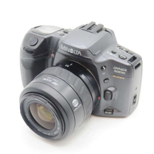 A Minolta Dynax 500si Super camera with a detachable AF Zoom lens attached, featuring a black body and various control buttons and dials visible on the top and side.