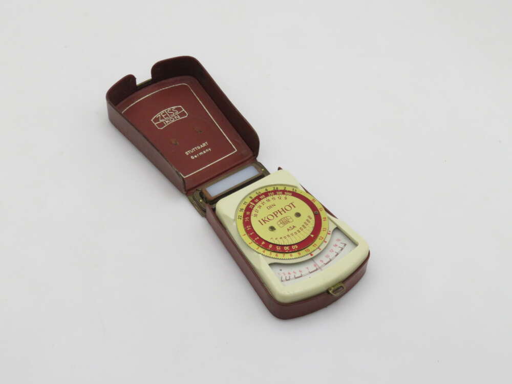 IMG_0630 A vintage Zeiss Ikon exposure meter in a brown leather case, featuring a circular dial labeled "Ikophot" and various exposure settings, with "Stuttgart, Germany" printed inside the case lid.