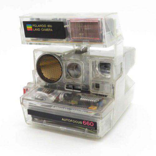 A vintage Polaroid 600 Land Camera with clear casing exposing its internal components, featuring an autofocus label and a classic design.