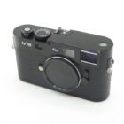 Black Leica M8 camera with textured body and lens cap, featuring a top dial and viewfinder.