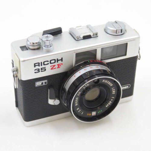 A vintage Ricoh 35 ZF rangefinder camera with a silver top, black textured body, and a Rikenon f/2.8 lens.