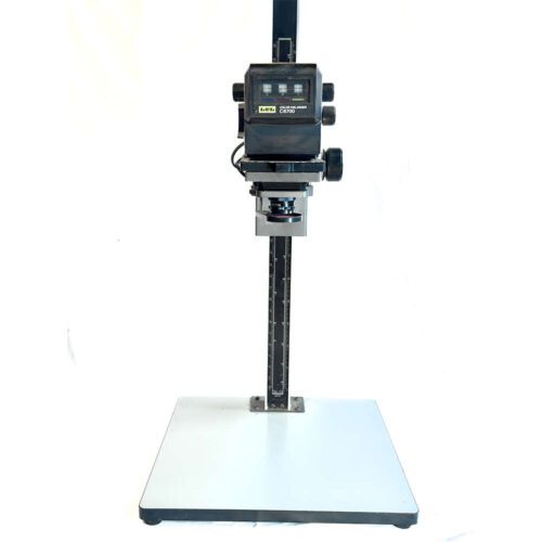 A photographic enlarger with a rectangular base, vertical column, and adjustable head for printing photographs from negatives.
