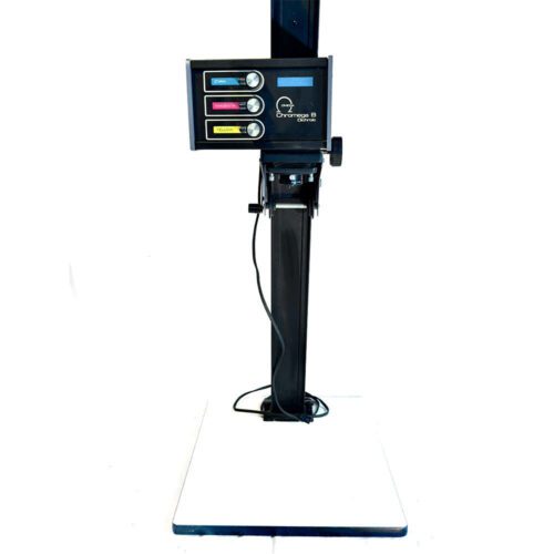 An Omega Chromega B enlarger, featuring a column with an adjustable head and a control panel displaying cyan, magenta, and yellow dials, standing on a white base.