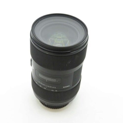 A Sigma camera lens with a focal length of 18-35mm and a maximum aperture of 1.8, featuring a smooth black exterior and visible lens markings, standing upright against a plain white background.