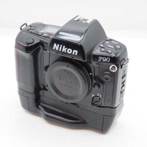 A Nikon F90 film camera with a black body and various control buttons, shown with a lens cap on, against a plain white background.