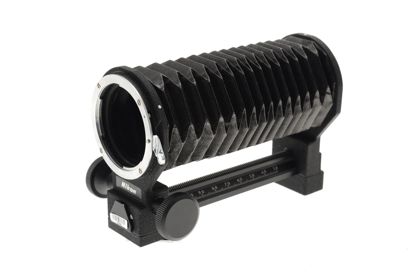 nikon_20PB-3_20bellows-_20kh-9916 A Nikon camera bellows extension with a black accordion-like body and adjustment knobs, used for macro photography, mounted on a black rail with a scale.
