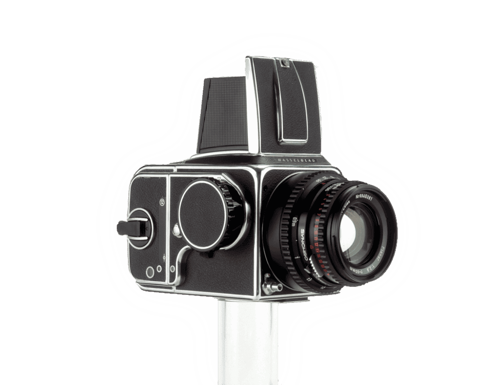 A medium format Hasselblad 500 series camera with a black body and a large lens, mounted on a white stand, against a white background.