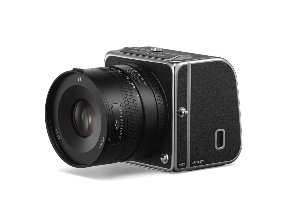 A Hasselblad 907X camera with a CFV II 50C digital back, featuring a sleek black body with silver accents and a large lens with detailed branding and markings.