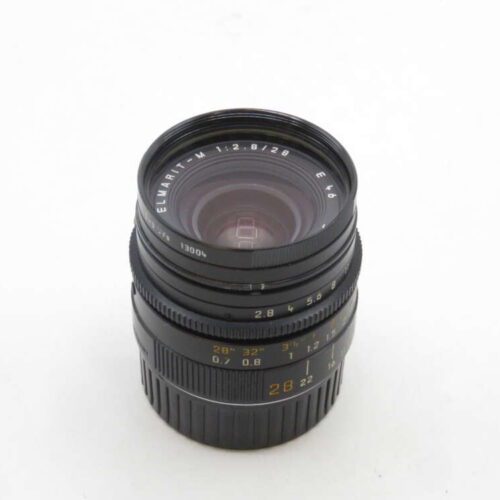 A camera lens with a black exterior and labeled with "ELMARIT-M 1:2.8/28" visible on the rim, showing its focal length and aperture specifications.