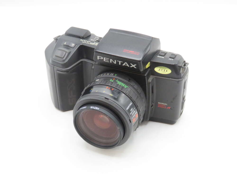 IMG_1482 A vintage Pentax SF-X film camera with a large lens and manual settings, featuring a black body and visible brand markings.