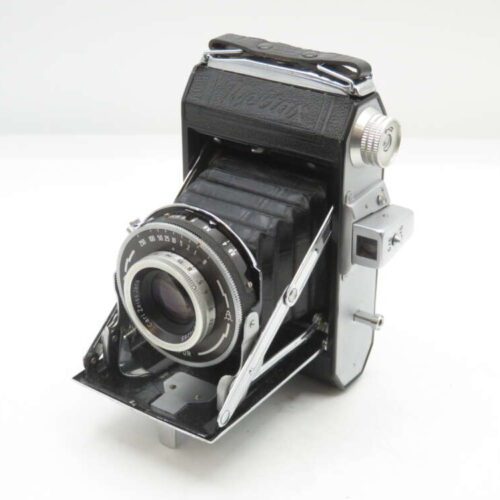 A vintage folding camera with black leather and silver metal components, featuring a bellows mechanism and a lens with engraved settings and adjustments, displayed against a plain white background.