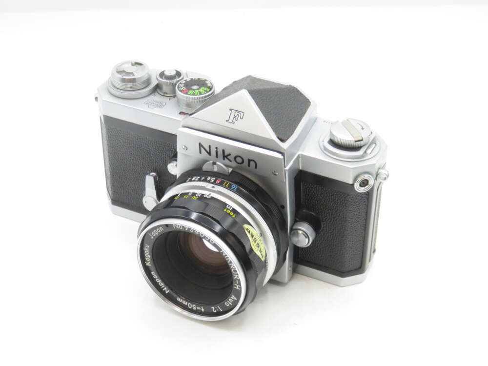 IMG_1498 A vintage Nikon F camera with a 50mm f/2 lens, featuring a silver and black body with manual controls and a classic design.