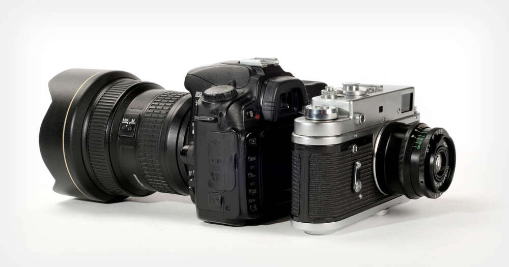 A modern DSLR camera with a large zoom lens next to a vintage film camera with a smaller lens, both placed side by side on a white background.