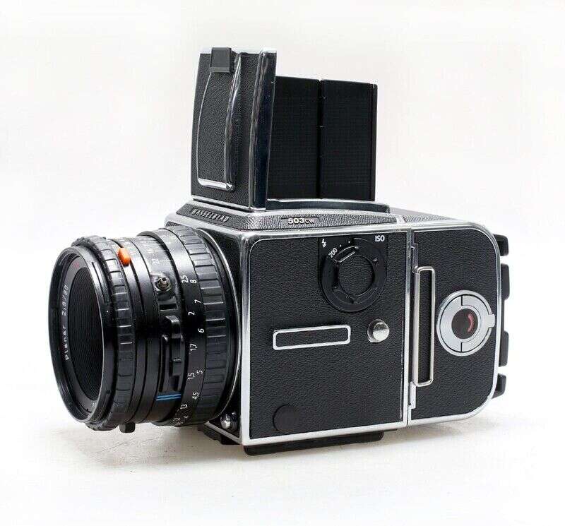 A vintage Hasselblad 503 CX medium format film camera with a lens attached, featuring a waist-level viewfinder and black textured body with silver accents.