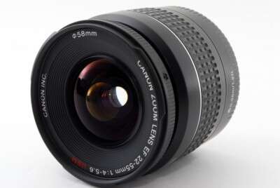 A close-up image of a Canon 58mm zoom lens with textured grips and a visible lens aperture.