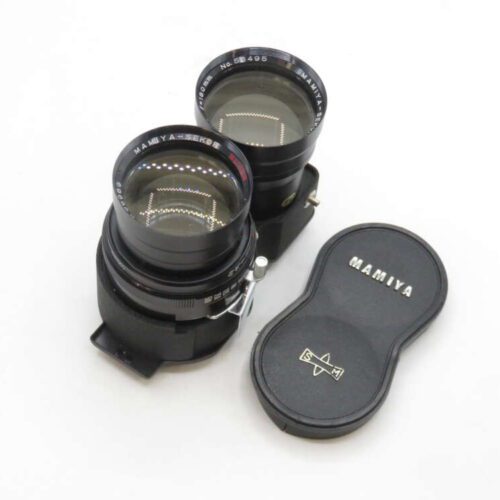 Two Mamiya camera lenses with a black Mamiya lens cap beside them on a white background.