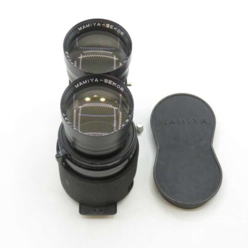 A pair of Mamiya-Sekor camera lenses stacked vertically, with a black lens cap bearing the Mamiya logo placed beside them on a white surface.