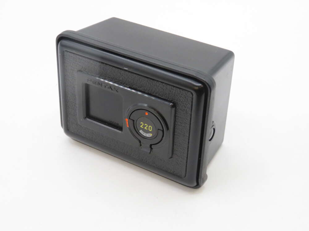 IMG_1827 A black Pentax film back accessory featuring a rectangular shape and a circular dial indicating "220."