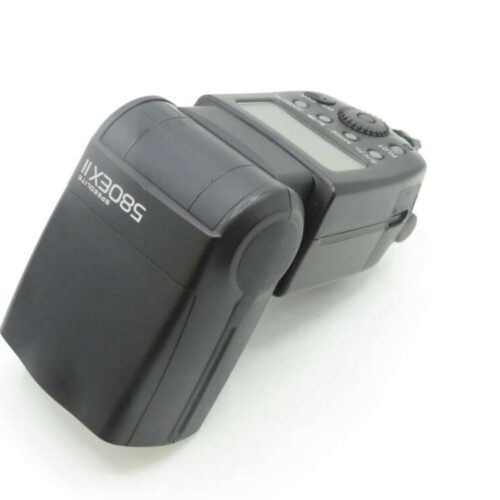 A Canon Speedlite 580EX II flash unit, featuring a black body with a tiltable head and a control panel with buttons and a dial on top.