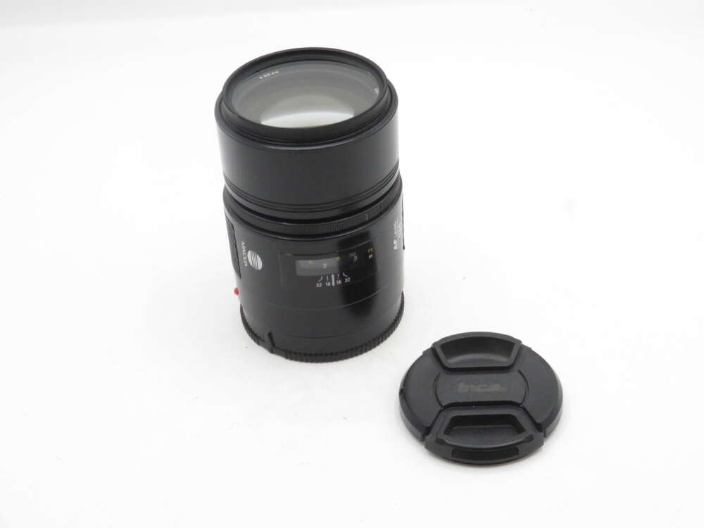IMG_1932 Black camera lens with a separate lens cap, shown on a white background.