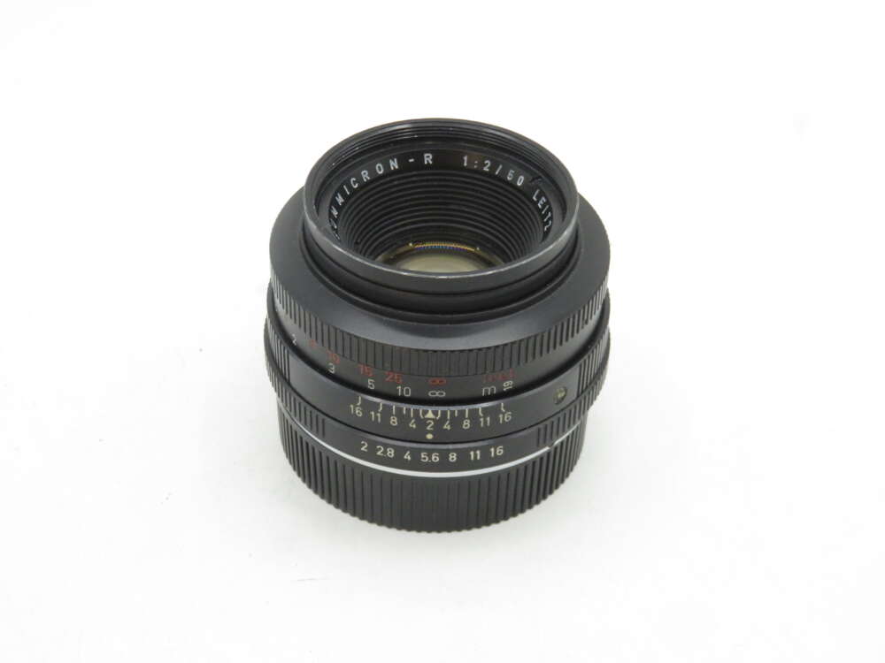 IMG_1956 A Leica Summicron-R 50mm f/2 camera lens with focus and aperture rings visible against a plain white background.